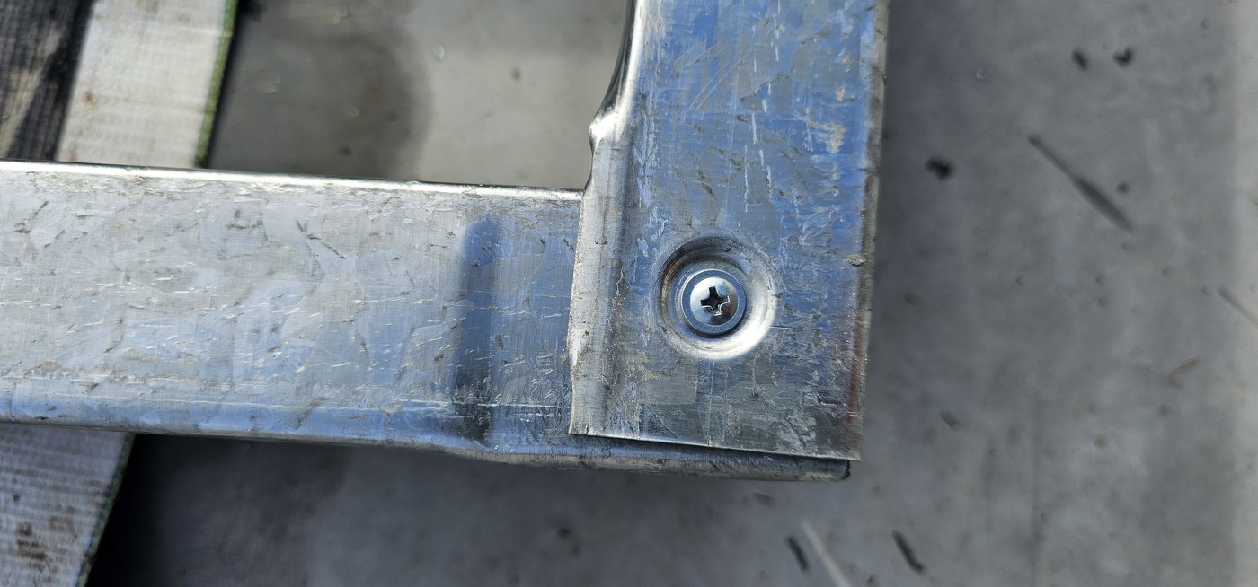Fotografia de obra da mesma ligação: a ponta desamassada do perfil galvanizado
              encaixada e aparafusada, sem corte nem solda.