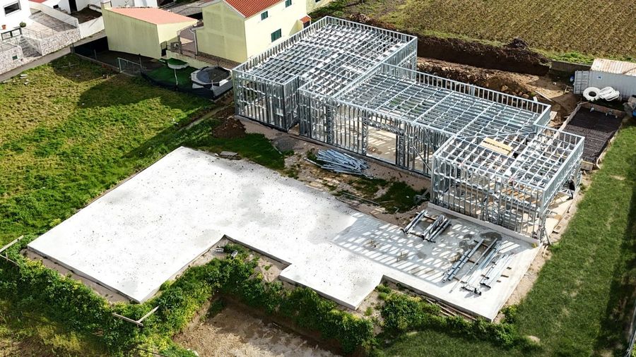 Moradia Patameira vista de cima: implantação em light steel frame sobre a
                  laje, rodeada de campo.